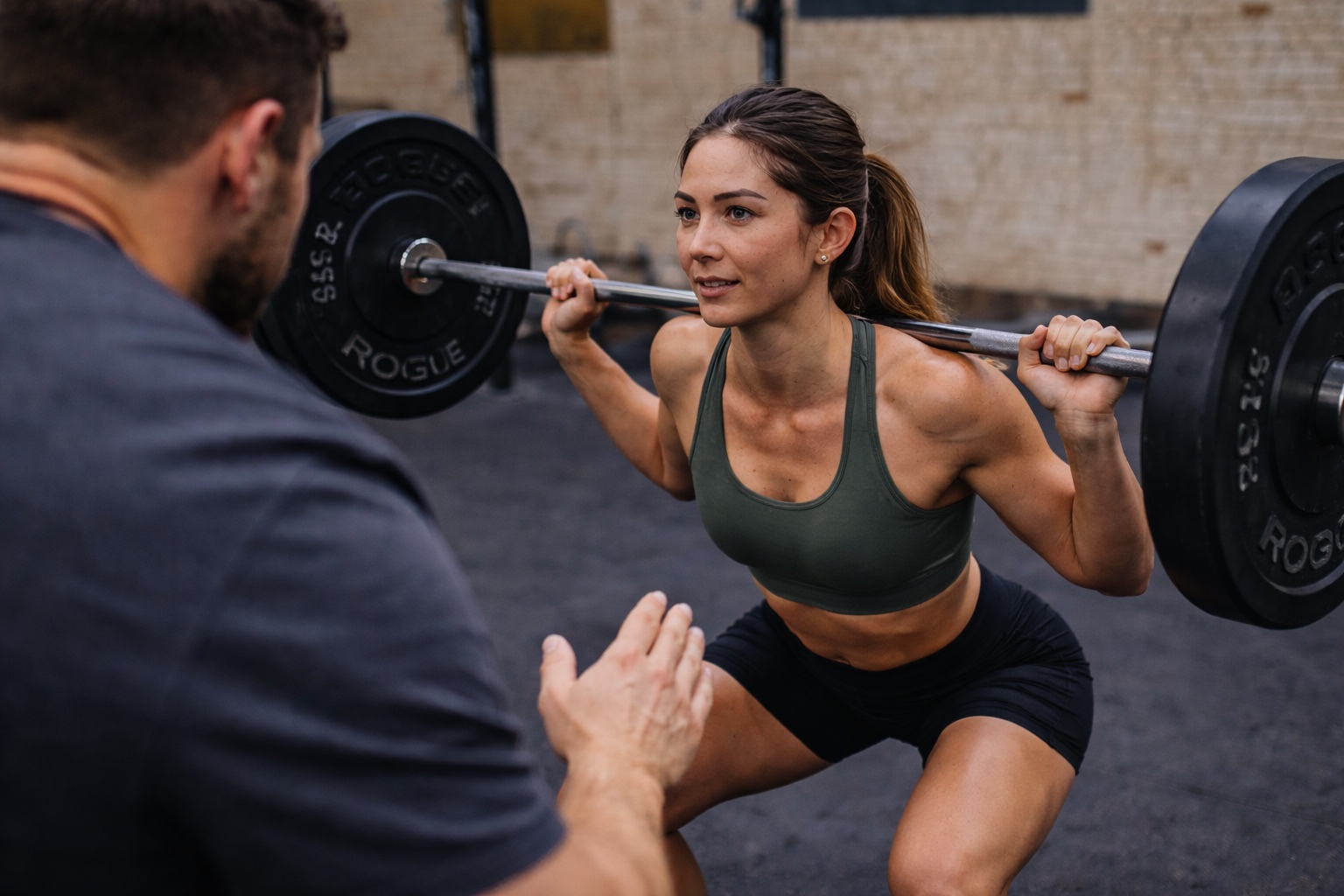 A coach working with a member on the gym floor