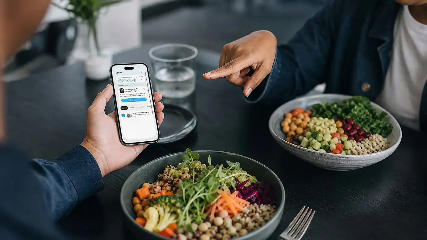 Two people with healthy bowls, one holding the HSN app.